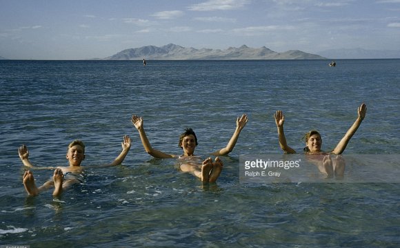 Three smiling teens float