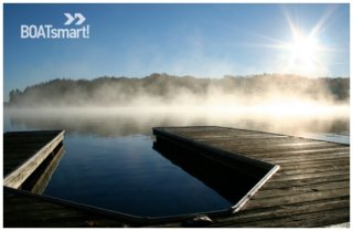 A picture of a dock with mist on the water.