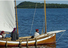A wood sailboat - called a Mackinaw - approaches a dock at Grand Portage on Lake Superior.